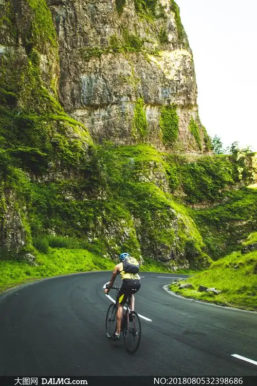 山间公路上骑行的男子摄影高清图片