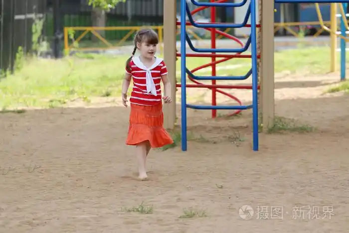 赤脚穿着裙子的小女孩走在沙滩上孩子们的操场上