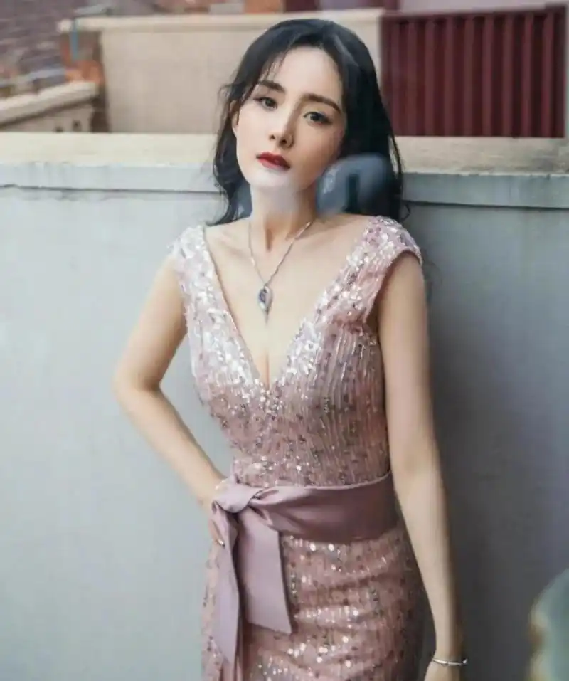 杨幂一条深v的亮片连衣裙搭配长卷发,女人味十足,身材凹凸有致,再系上