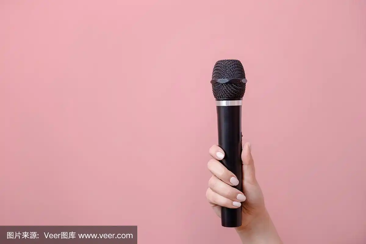 女性手握麦克风,粉红色背景