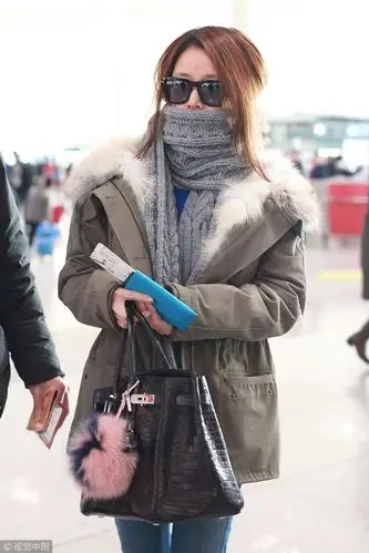 林心如现身机场 见镜头亲切挥手秀钻戒