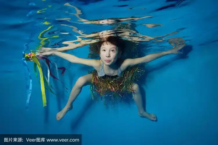 快乐的小女孩穿着泳衣在水下游泳和玩丝带.他的手臂和姿势.肖像.