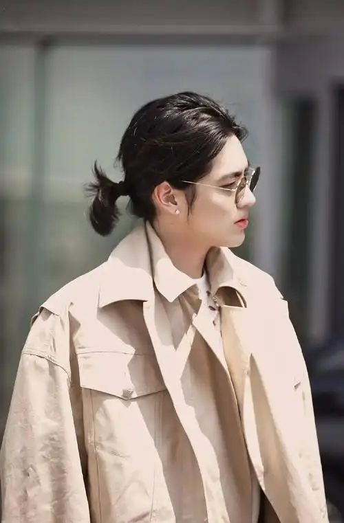 吴亦凡穿风衣长裤走机场,戴墨镜斯文帅气,小辫子扎成花苞也时髦