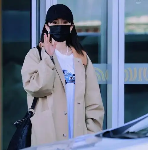 当天杨幂一身入秋穿搭落地北京,戴着黑色的帽子和口罩,打扮低调,上身