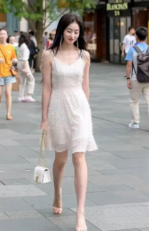 美女穿一条白色吊带裙充满了时尚气息