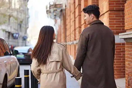 甜蜜情侣冬季户外牵手逛街背影图片素材