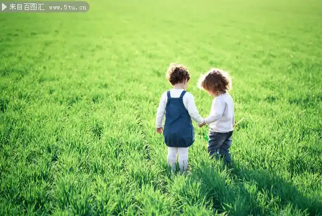 草地上牵手的孩子图片