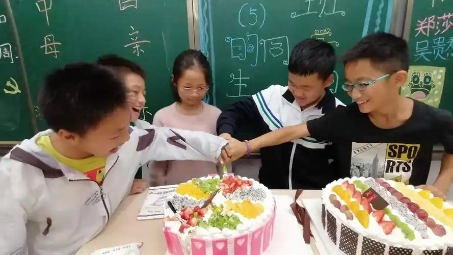 过生日的五位同学快乐地切着蛋糕