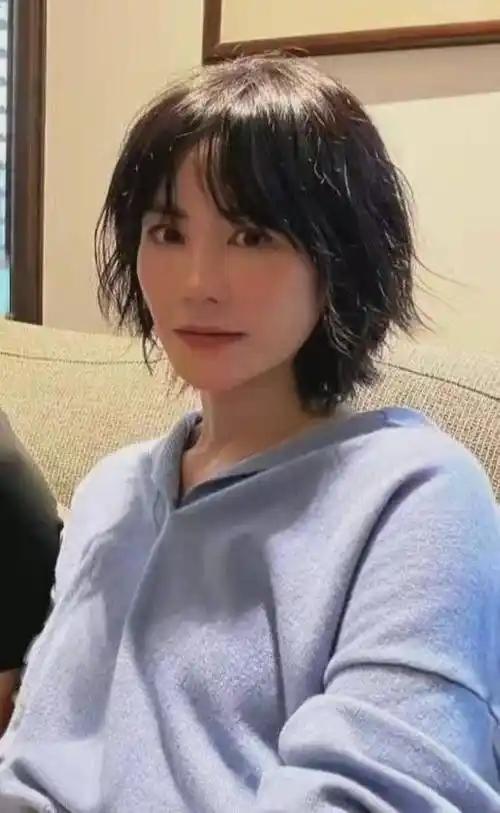 化着精致的女神妆,凌乱的及肩短发,搭配淡蓝色的上衣,让王菲看起来