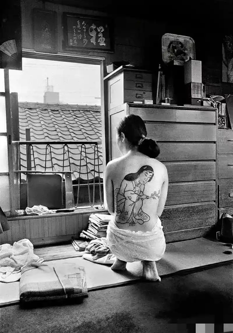 老照片:70年代,日本,著名纹身师崛文正在为一个女孩纹身.