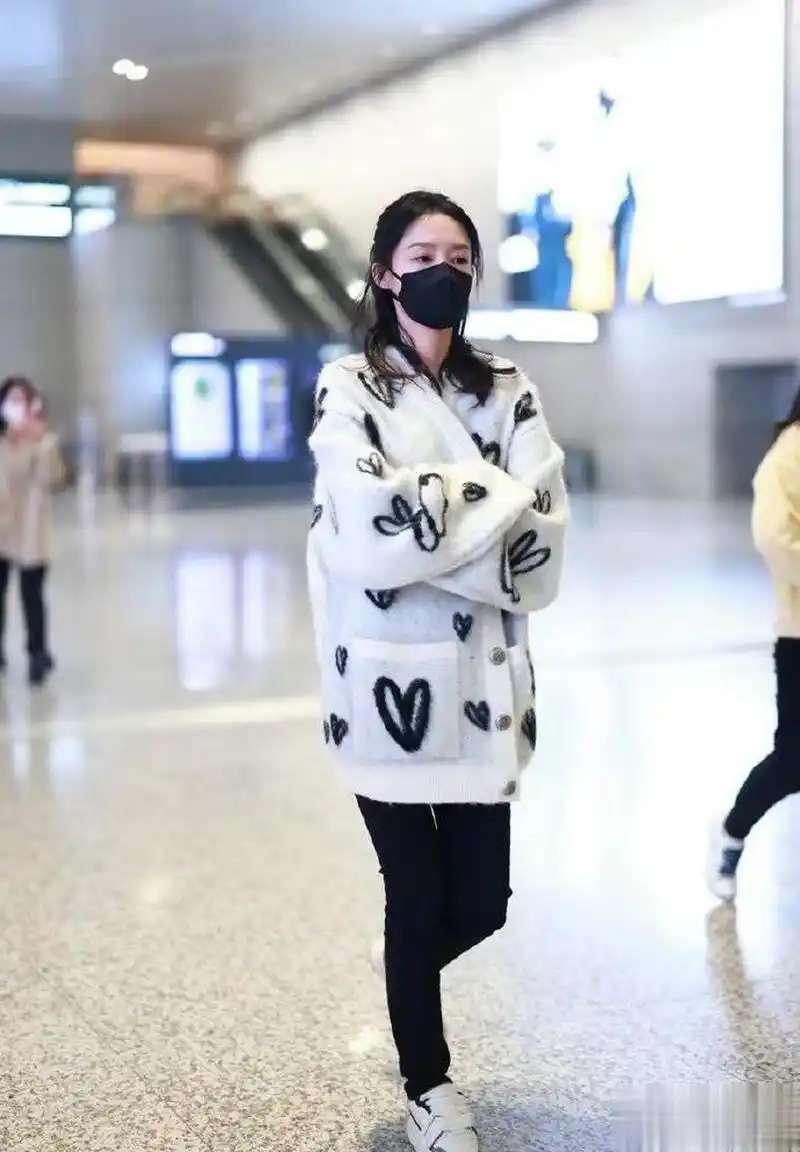 李沁机场照 身穿白色印花开衫简约低调.