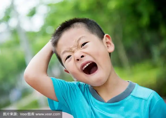 亚洲小男孩挠着头