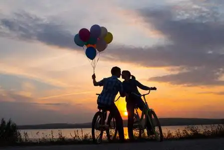 两个人在浪漫的约会中互相看着对方.年轻夫妇坐在自行车上.