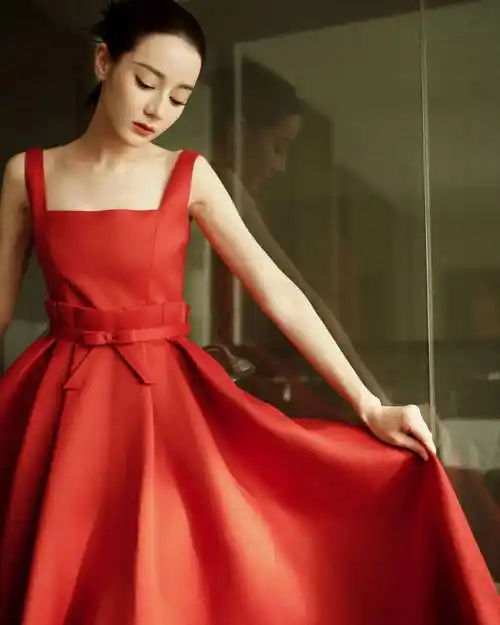 迪丽热巴身穿一袭红色长裙,她俏脸清丽脱俗,单手拿着玻璃杯,露出白皙