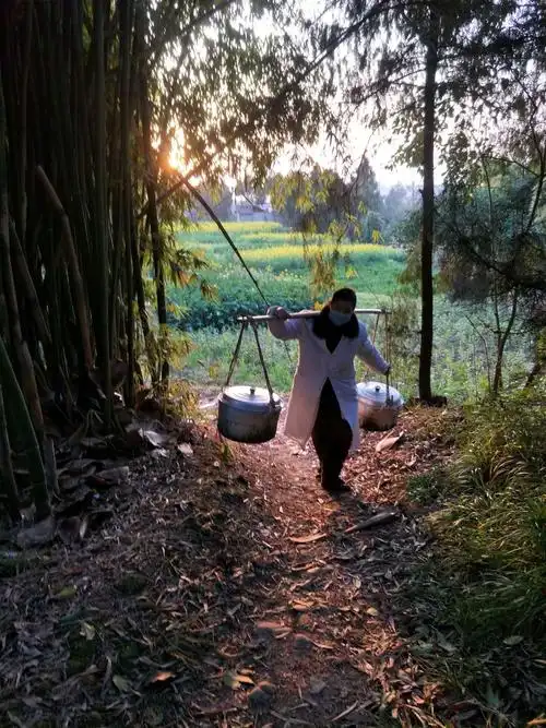 一个人来来回回去送浪费时间,他索性拿起家中的扁担和绳子,将两大锅汤