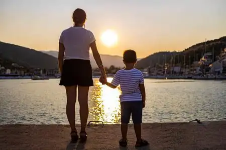 日落时母亲和儿子手牵手照片