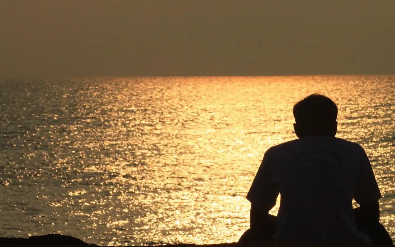 夕阳下一个人看海的孤独背影