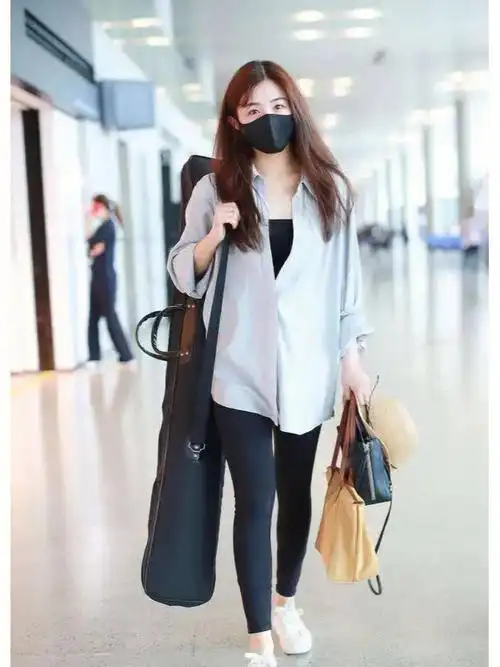 张含韵亮相机场冰蓝色衬衫搭配无痕裤