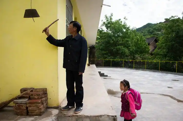 放学时,李占荣敲响自制的"下课铃",田婷一个人在排队等待和校长告别.