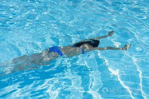 女子在游泳池里跳水.年轻美丽的女孩在游泳池里游泳.