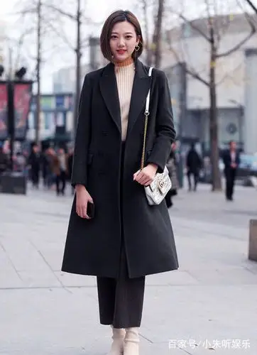 小姐姐穿着米黄色毛衣搭配黑色长款风衣,充满了女人味.