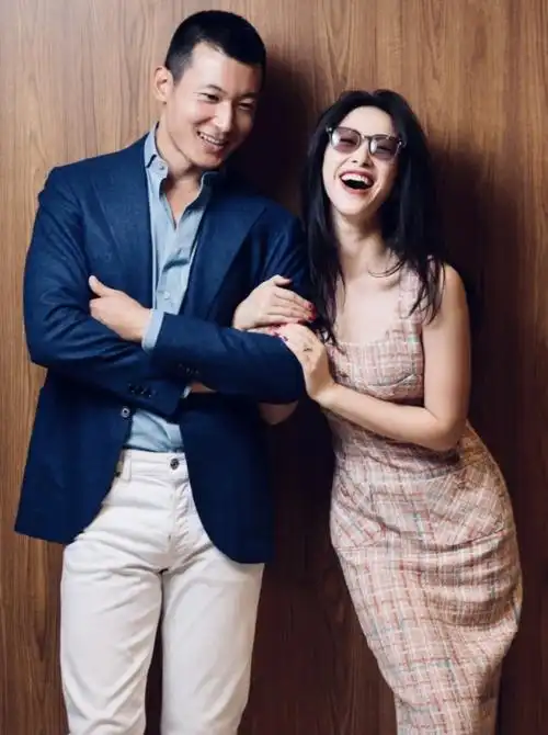 王昀佳穿着蓝色西装搭配白色裤子,帅气有型,朱珠挽着老公的手臂,放肆