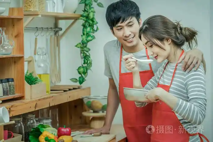 亚洲恋人或情侣在厨房房间里烹调和品尝食物在现代房子, 情侣和生活