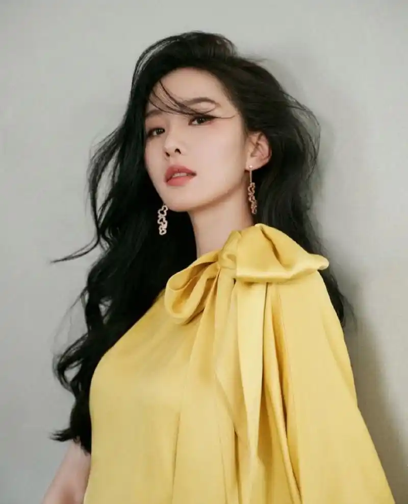 刘诗诗一袭光泽极佳的明黄色蝴蝶结开叉礼裙,明媚优雅,非常的贵气.