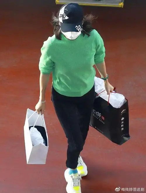 机场街拍章子怡绿色针织衫黑色牛仔裤活泼美丽