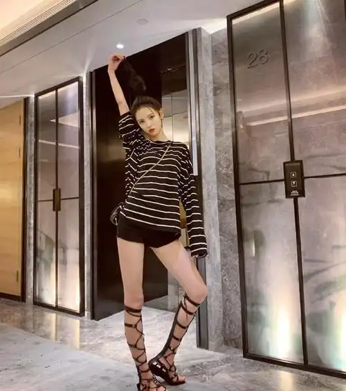 张予曦上身穿条纹上衣,下身搭黑色超短裤,超级时髦酷帅,脚踩一双绑带