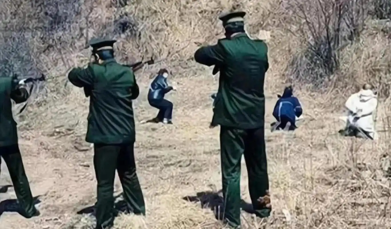 在枪毙人的现场,武警荷枪实弹对准了几个跪倒在地上的男女死刑犯,其中