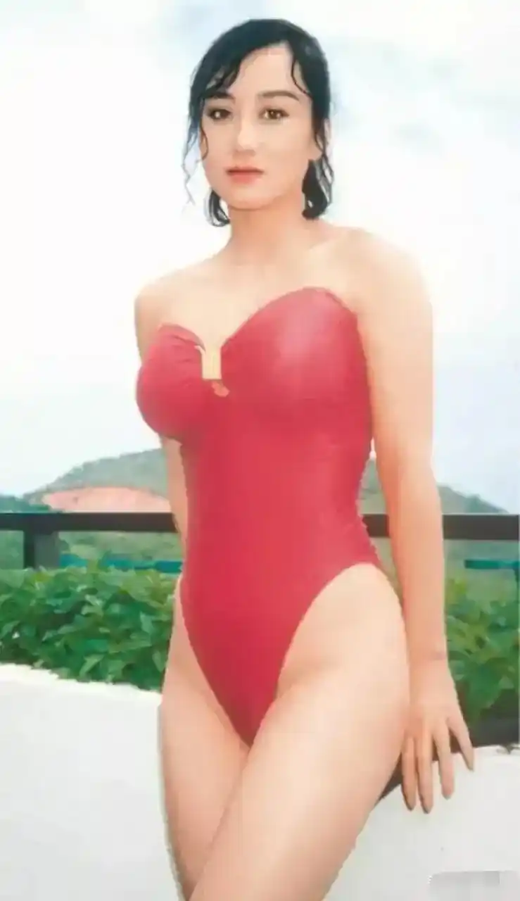 这是利智年轻时的泳装照.利智穿着一件红色的紧身泳装,身材的完美充分