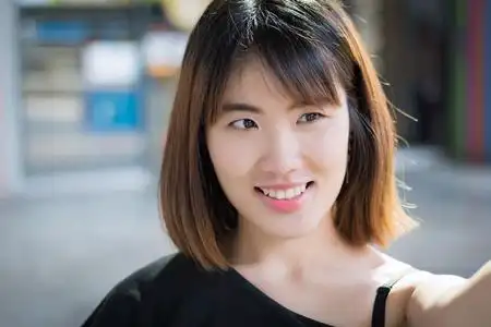 快乐女人笑脸肖像;积极放松的亚洲女性微笑的城市环境;亚洲妇女青年