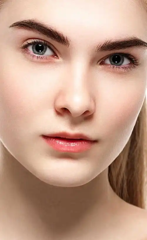 白色背景下触摸自己脸部的女人