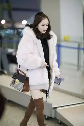 杨幂大冬天仍能秀身材,机场裹毛绒大衣凹"下衣失踪",为美真拼