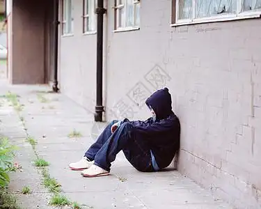空房间靠墙靠墙坐着的男孩背景