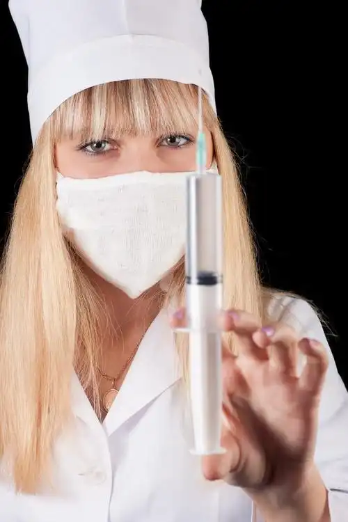 护士,护士举行注射器在黑色背景上的手.