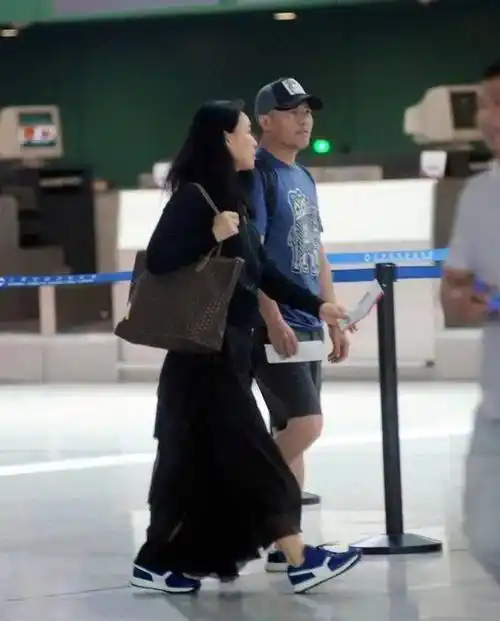 那英一家三口罕见走机场,56岁打扮个性像时髦女王,丈夫儿女陪伴身旁让