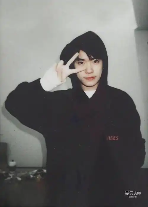 偏暗色系的背景照片,酷酷的表情,加上简单可爱的剪刀手,给人一种高冷
