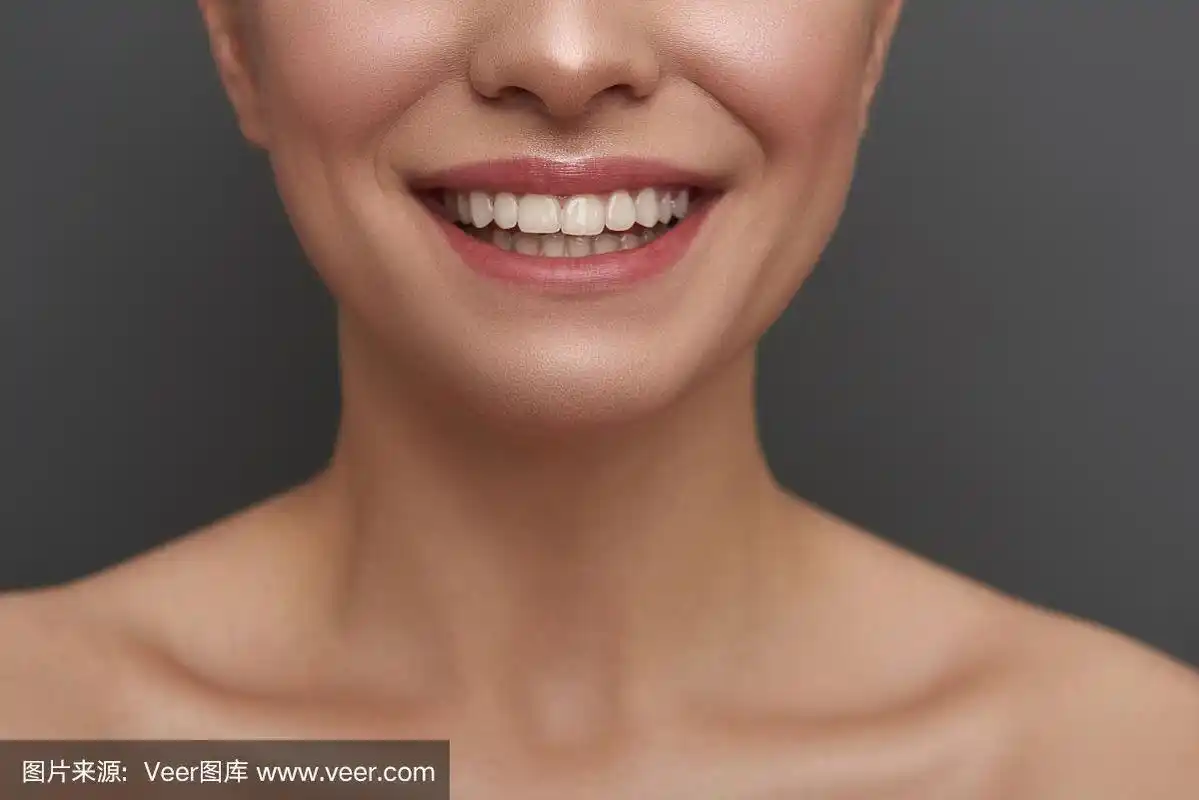 近距离的女人露出她的牙齿,而微笑