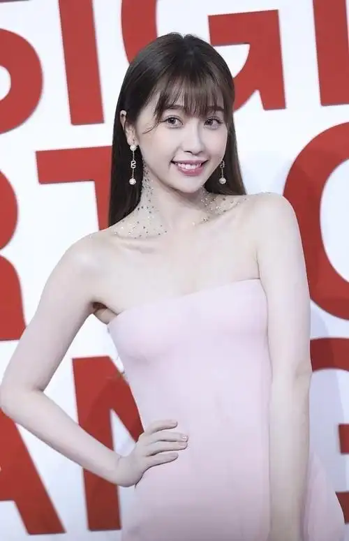 虞书欣穿粉色抹胸裙秀香肩配白色手袋挺优雅看得出富千金气质