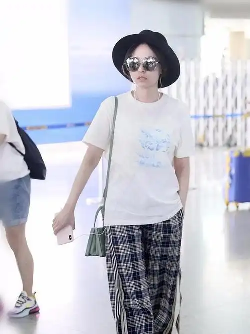 张靓颖素颜走机场,穿白色t恤搭格纹阔腿裤,活力清新哪像35岁?