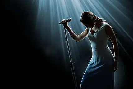 女歌手在舞台上拿着麦克风手提包包