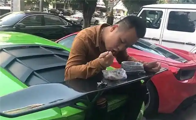 坐在豪车上吃盒饭骨头吐在几十万的尾翼上游客看人家脖子