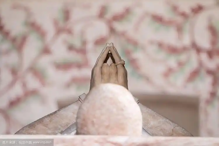 双手合十躺着的雕像