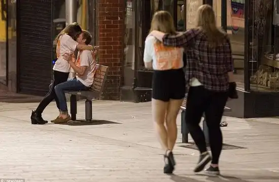 一对男女在市中心的长凳上进行亲密接触.
