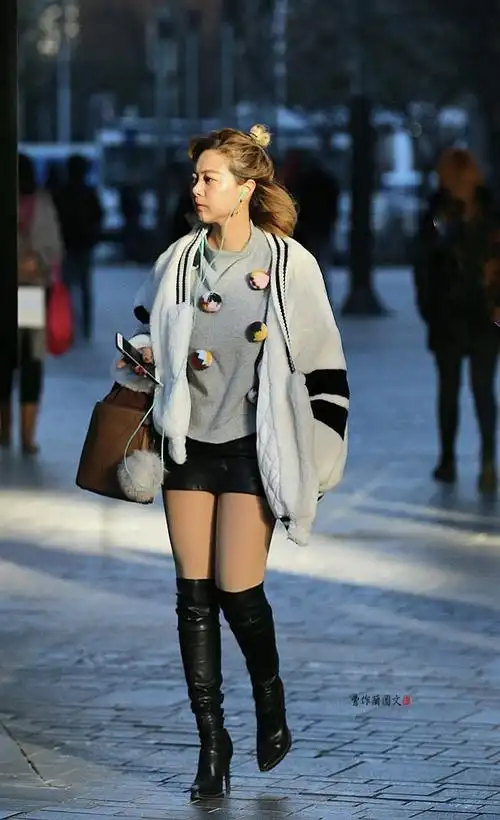 街拍高筒靴美女有点儿穿不够