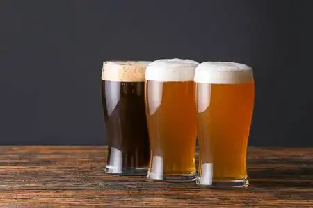 木桌上摆着几杯不同口味的啤酒照片