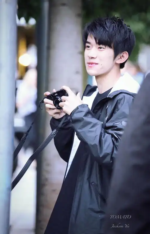 易烊千玺新闻170917捕捉异国他乡的易男友手拿相机微微一笑很撩人