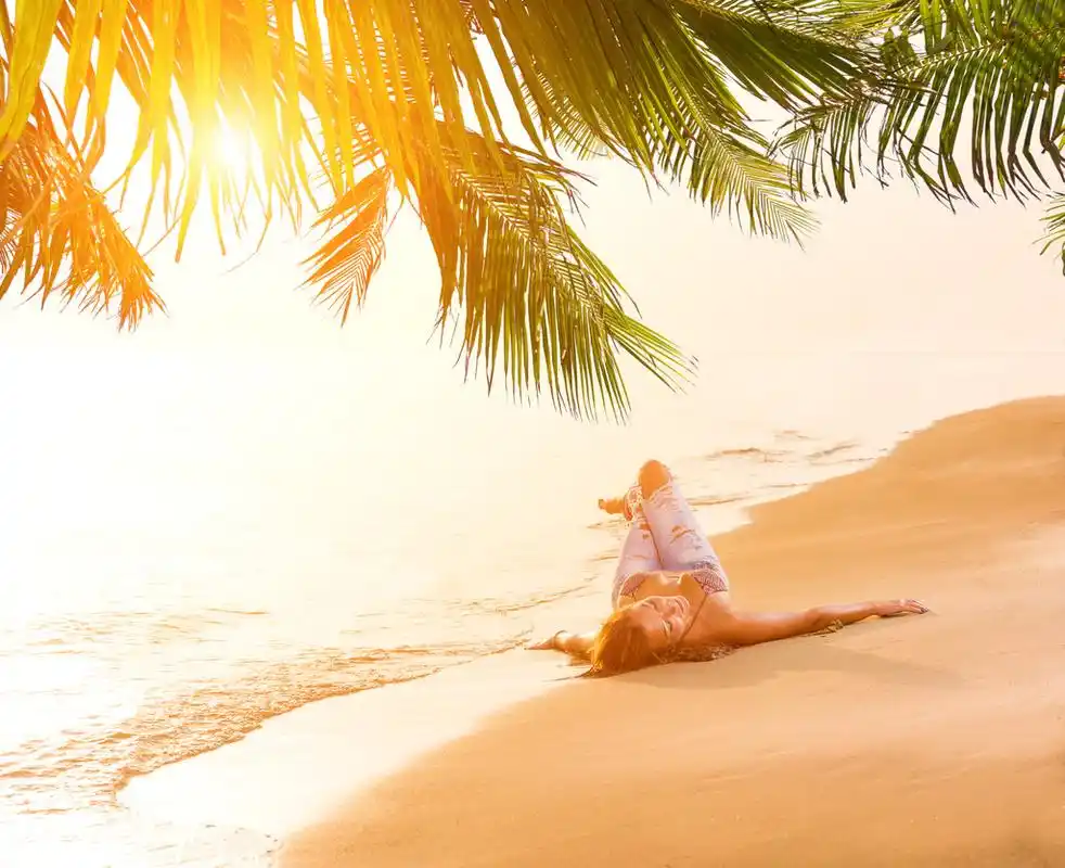 蓝色的牛仔裤和比基尼在海滩的女人